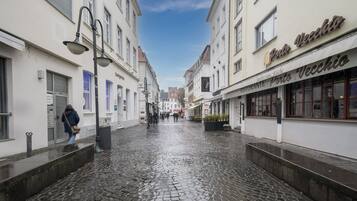 Eine Kopfsteinpflasterstraße mit Gebäuden an beiden Seiten, darunter ein Restaurant namens Porto Vecchio.