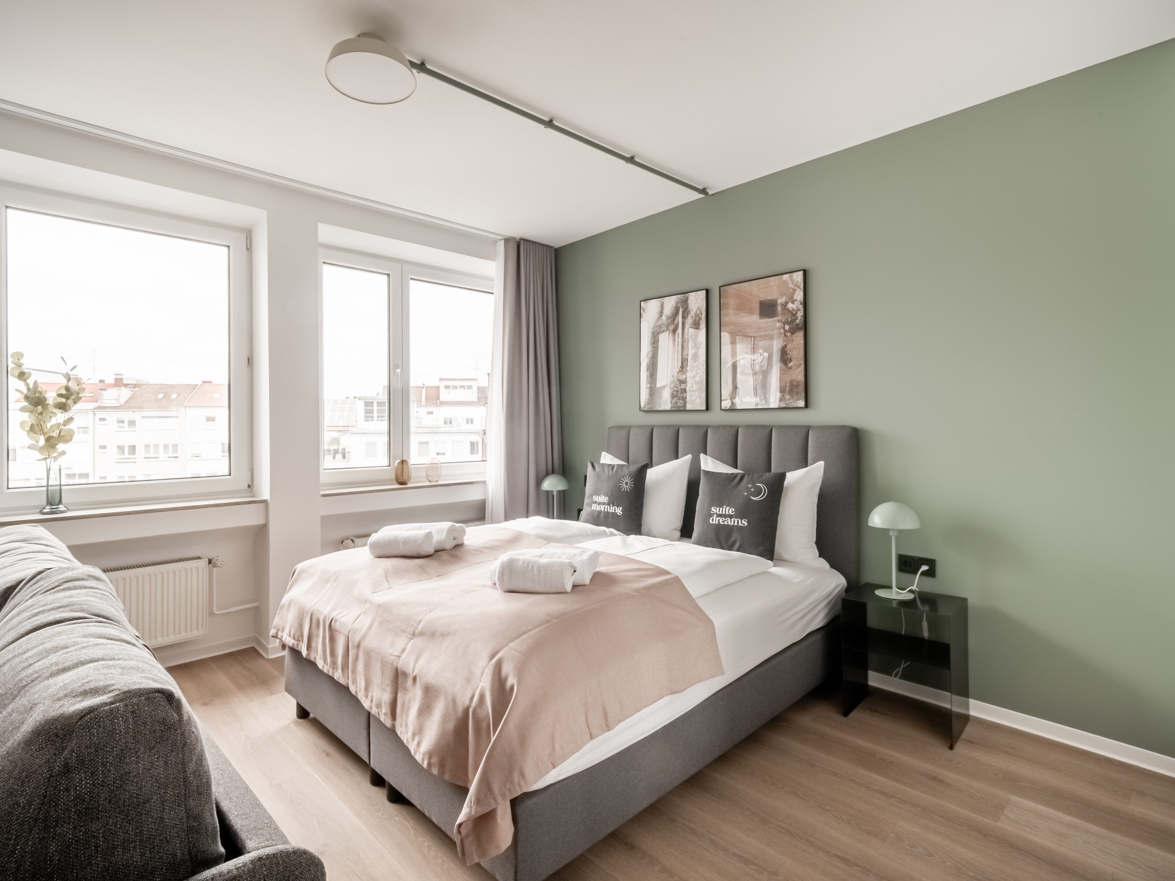 Un dormitorio moderno con una cama grande, mesitas de noche, una ventana con vistas y una obra de arte en la pared.
