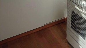 A compact kitchen with a sink, a microwave, and a stove. - Appartement Sympa à 50 m de la mer (Middelkerke)