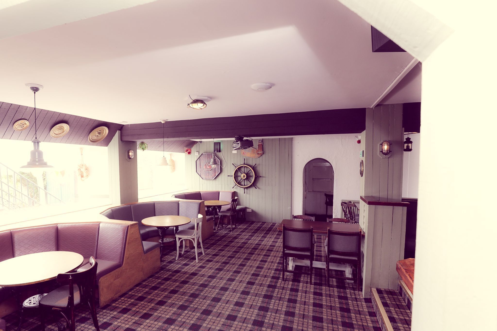 A restaurant with booths, tables, and a checkered floor.