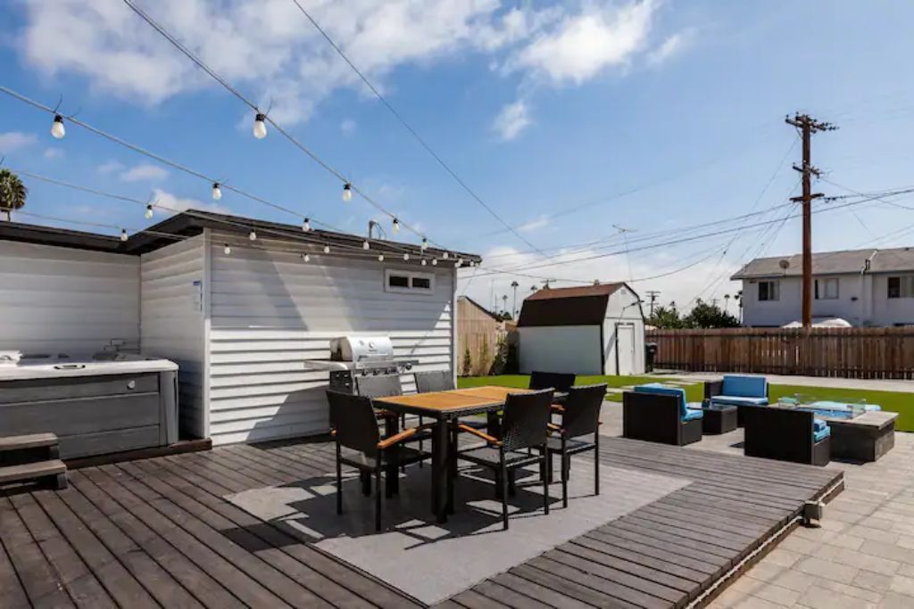 Eine Terrasse im Freien mit Grill, Sitzgelegenheit und Lichterkette.