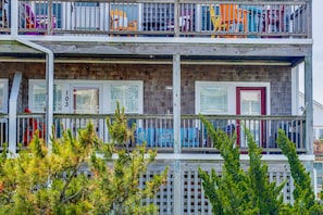 Un immeuble à plusieurs étages doté de balcons, de rampes en bois et d’une façade en briques.
