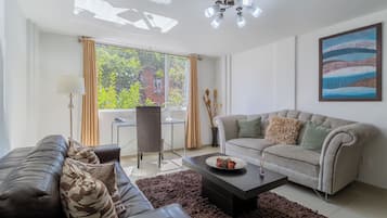 Suite Confort, 1 habitación | Área de sala de estar | Televisión de plasma