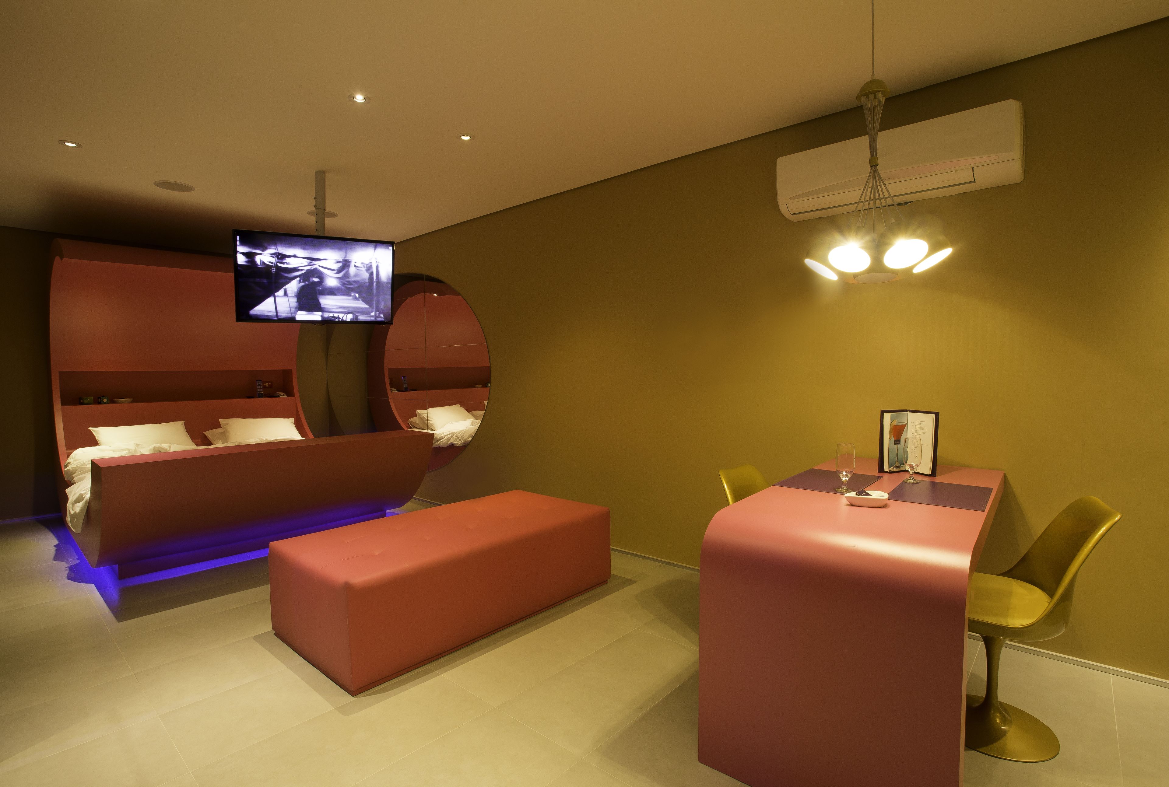 Ein modernes Hotelzimmer mit Bett, einem kleinen Tisch und einem Fernseher.