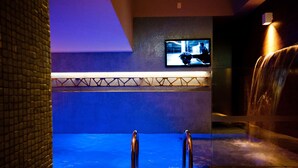 A spa area with a hot tub, a television mounted on the wall, and a water feature. - Lush Motel Ipiranga (São Paulo)