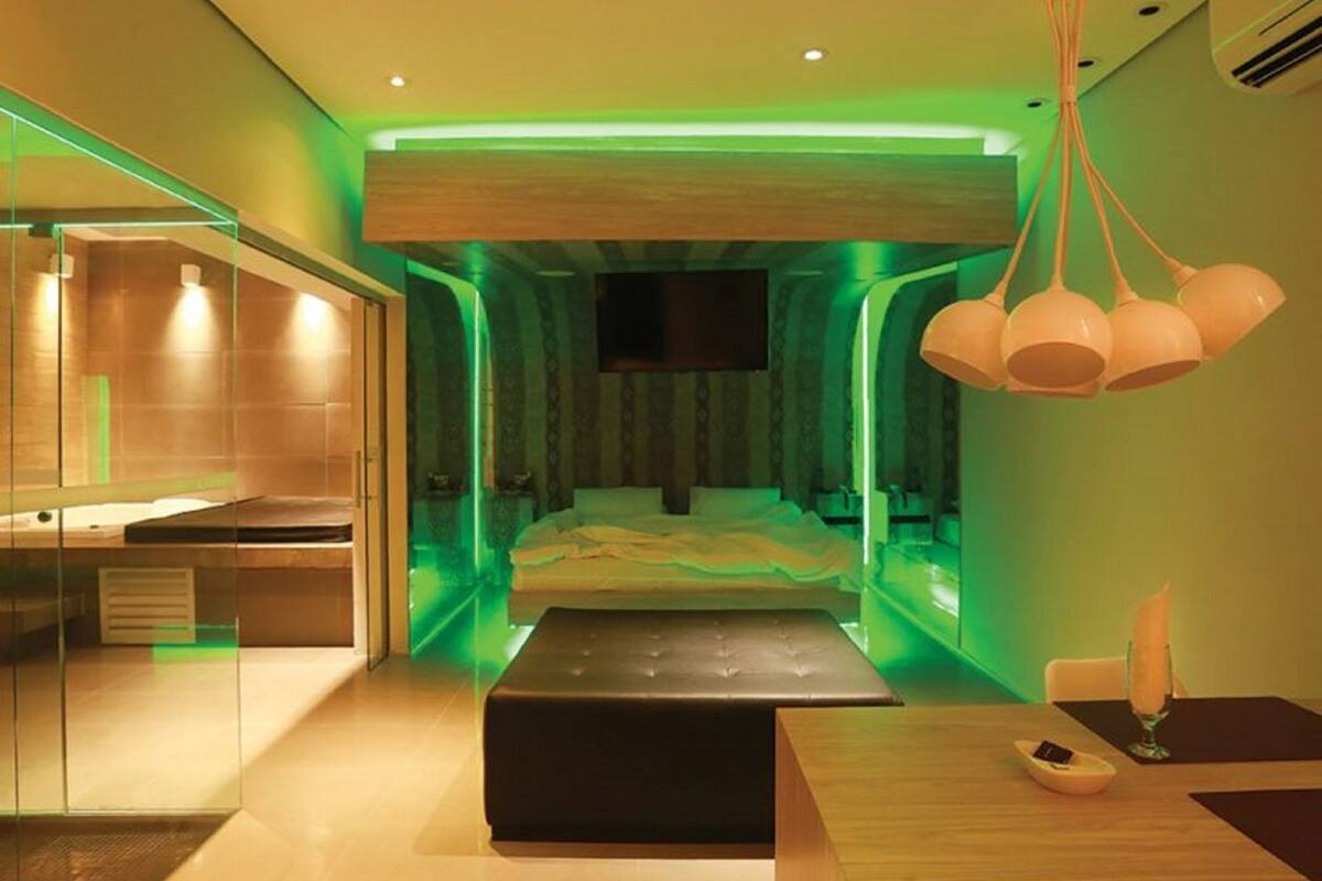 Un dormitorio moderno con una cama, una mesita de noche, un espejo y una lámpara colgante.