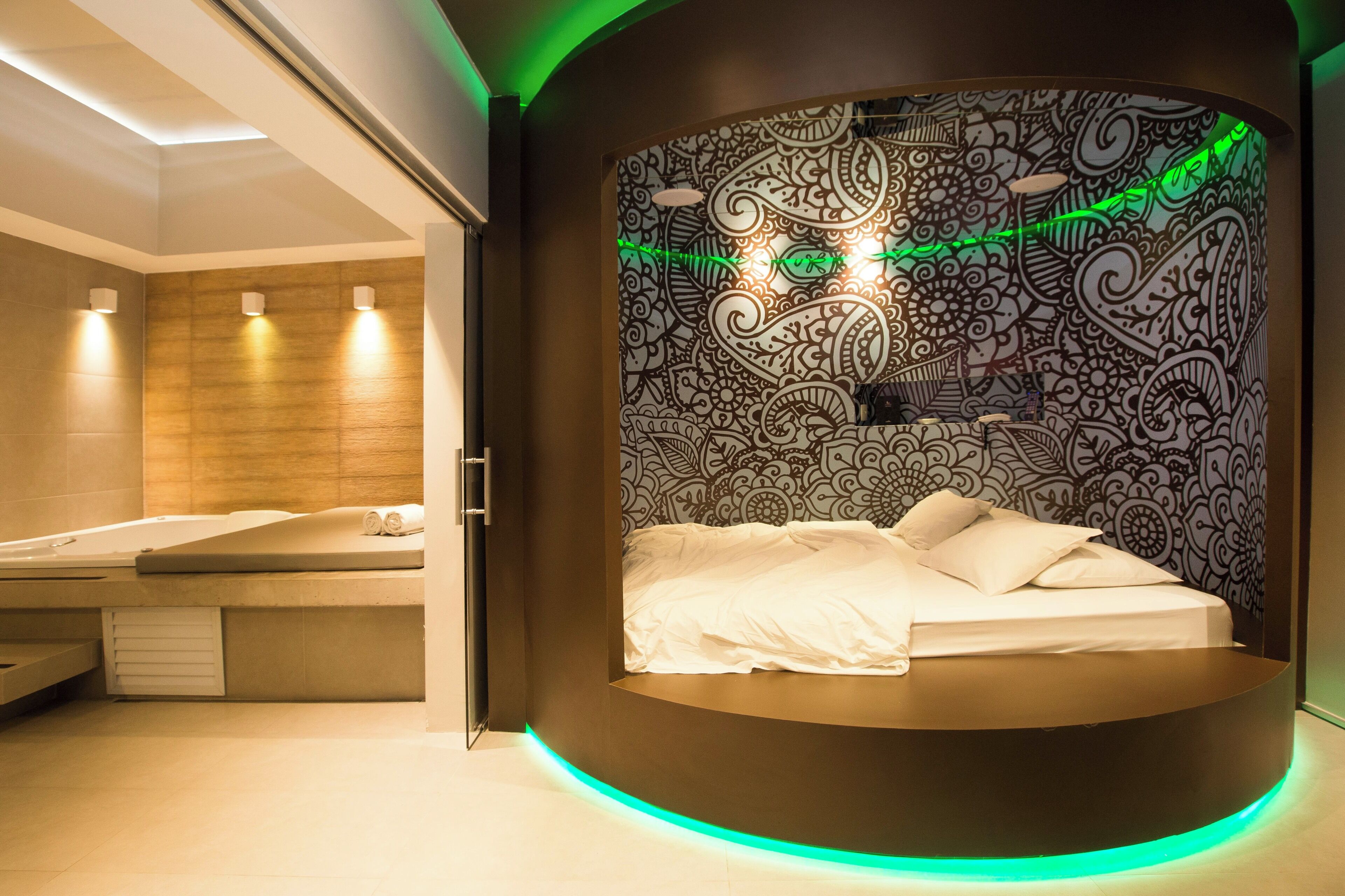 A modern bedroom with a circular bed, a wall with intricate patterns, and a wooden panel wall.