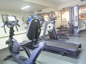 Een sportschool met hometrainers, loopbanden en krachtapparaten.
