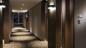 Un pasillo moderno de hotel con paneles de madera, piso alfombrado y un letrero que indica la habitación 1401.