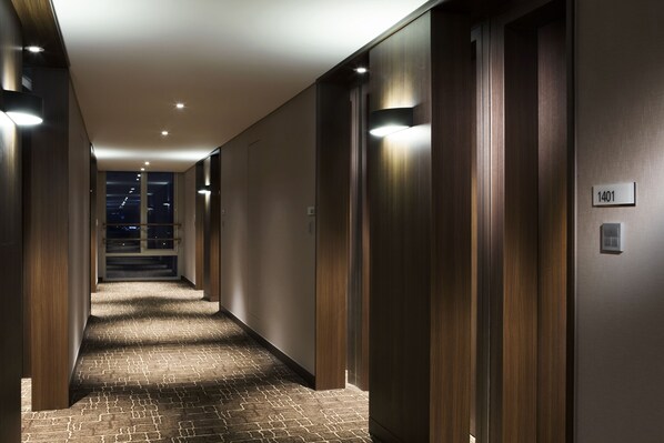 A modern hotel hallway with wooden paneling, a carpeted floor, and a sign indicating room number 1401. - LOTTE CITY HOTEL DAEJEON (Daejeon)