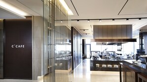 Un interior moderno de Caffè con un diseño elegante, que presenta un separador de vidrio, una zona de cocina central y una barra.