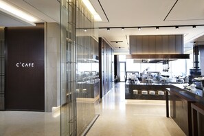 Un interior moderno de Caffè con un diseño elegante, que presenta un separador de vidrio, una zona de cocina central y una barra.