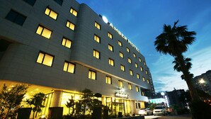 Een meerhoog hotel met verlichte ramen en een bord waarop 