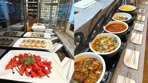 Een buffet met diverse gerechten, waaronder zeevruchten, salades en warme maaltijden.
