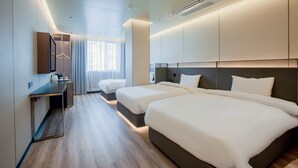 Een hotelkamer met twee bedden, een bureau en een kledingkast.