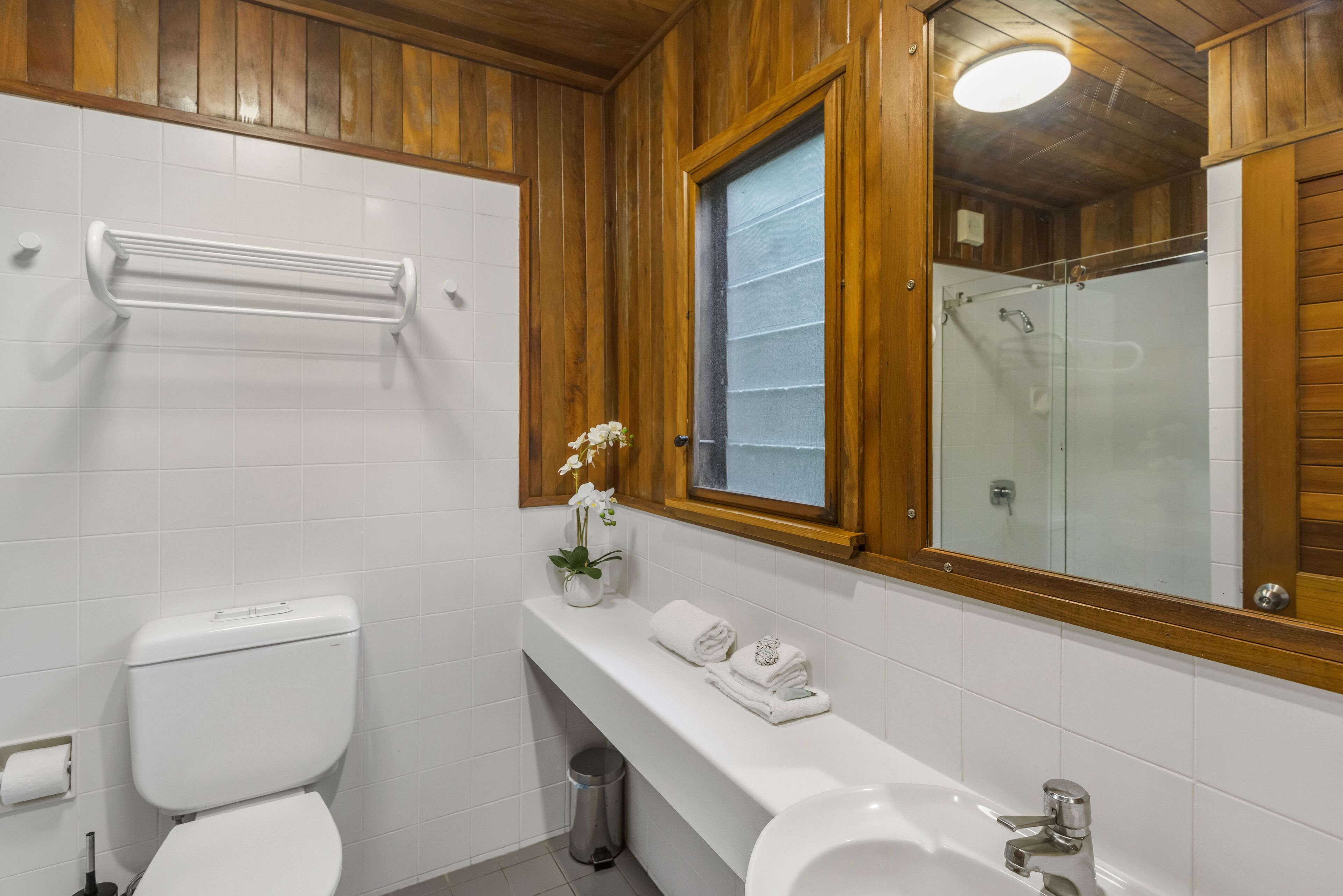 Un baño con inodoro, lavamanos y ducha.