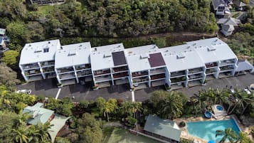 Hotel features a modern design with solar panels and lush green surroundings.