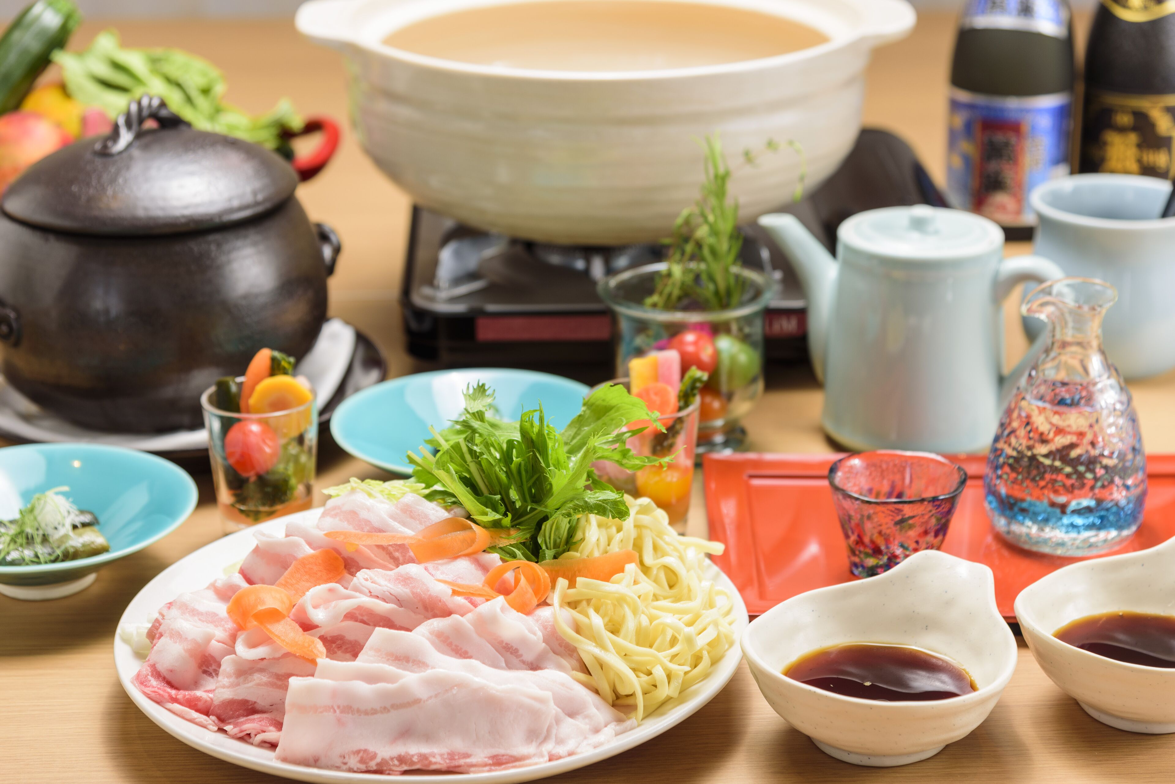 A table with various dishes, including sashimi, vegetables, and condiments.