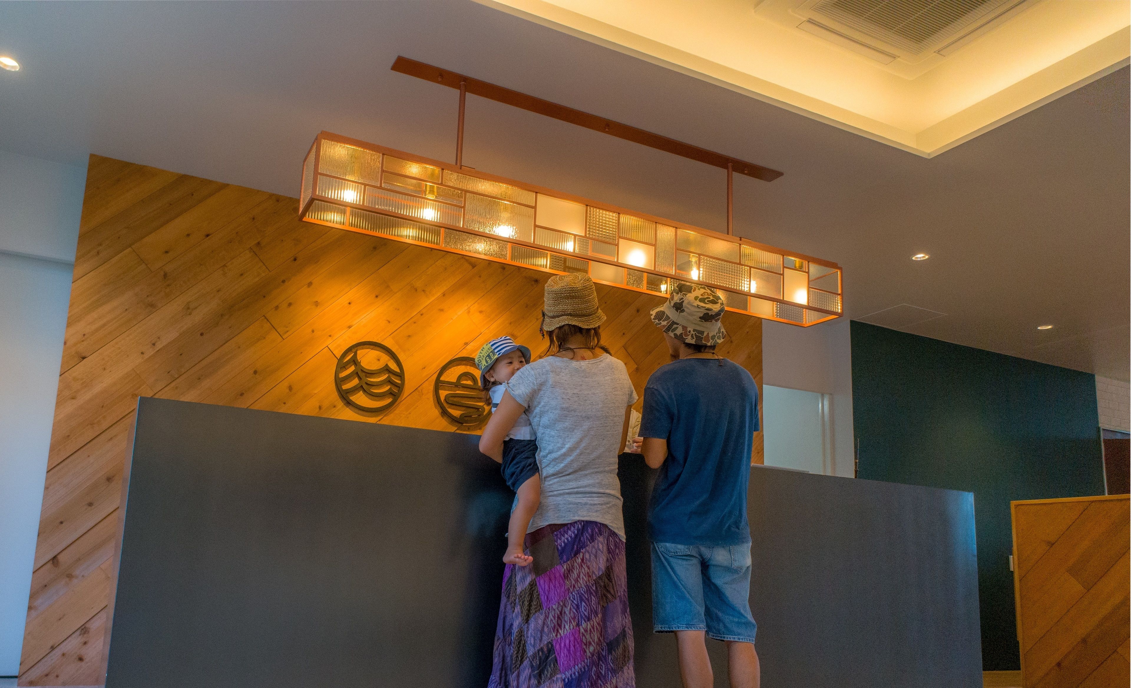 A reception area with a wooden wall and a modern light fixture.