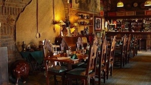 Un restaurante con mobiliario de madera, pared de ladrillo y diversas decoraciones.