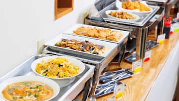 Een buffet met diverse gerechten, zoals soep, salade en gebakken vleeswaren.