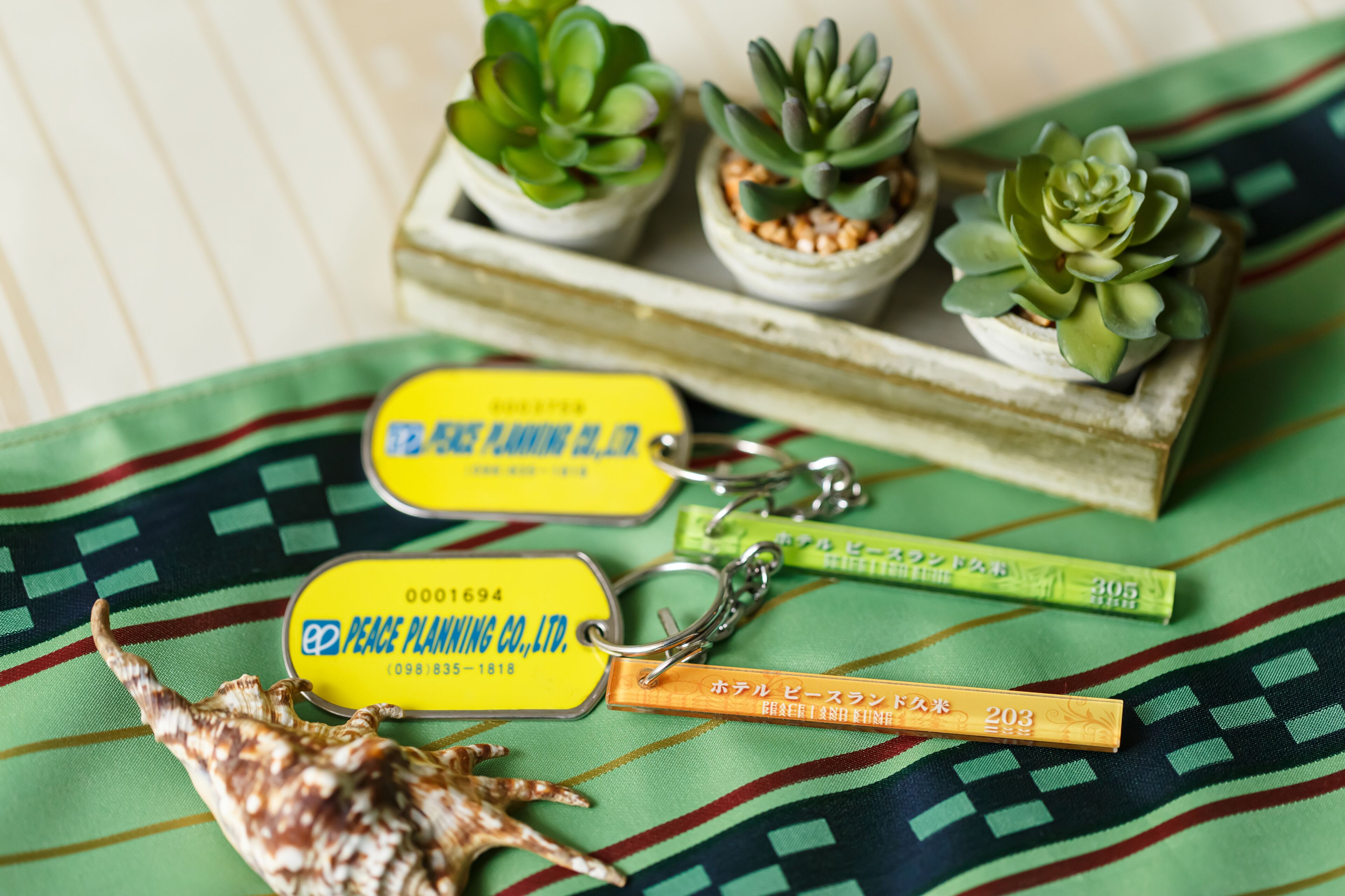 A keychain with a yellow tag, a green tag, and a small shell.