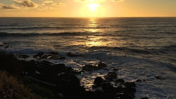 Ein Sonnenuntergang über dem Meer mit Wolken und Wellen.