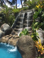 Una piscina al aire libre, sombrillas, sillones reclinables de piscina