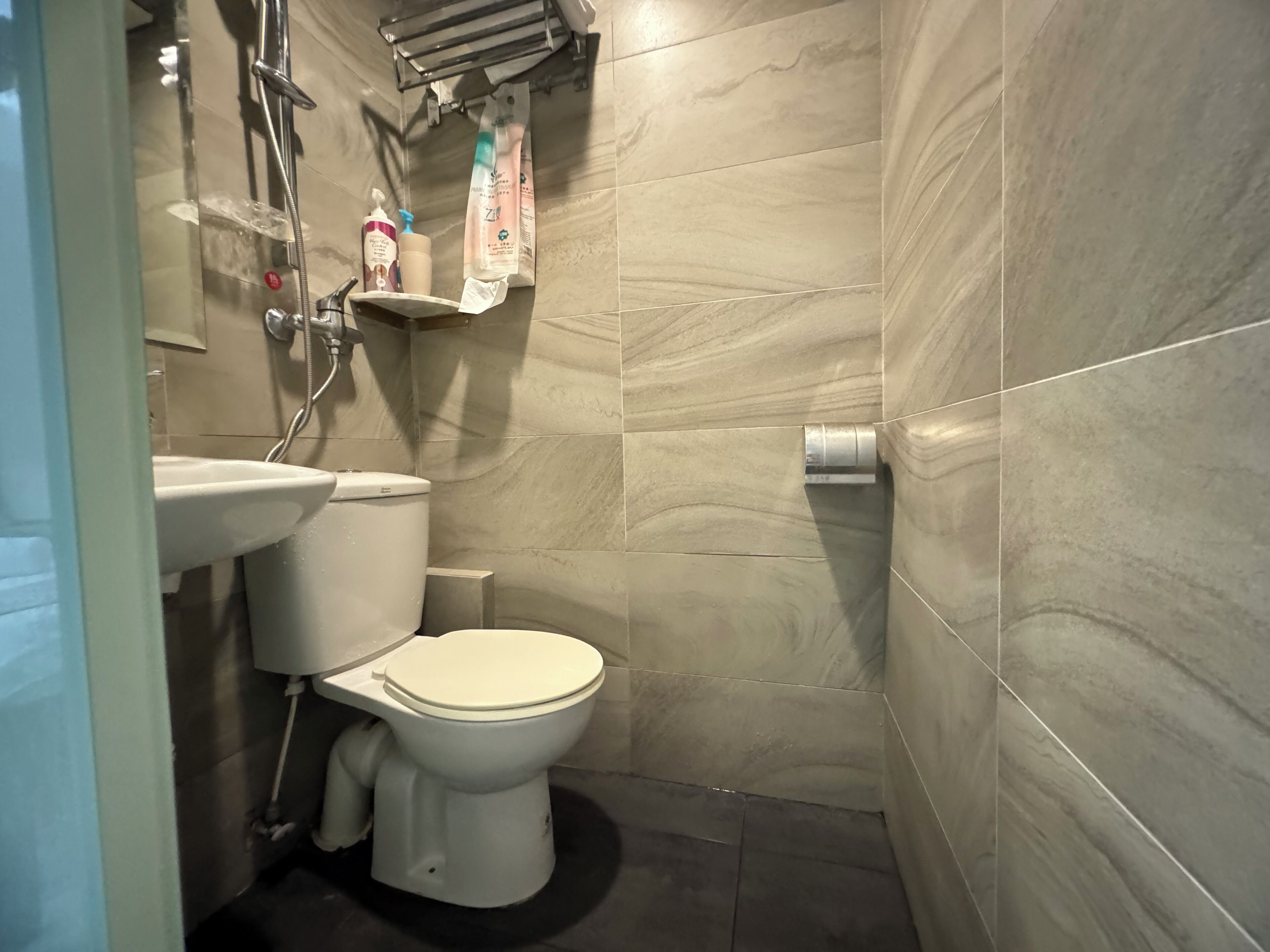A modern bathroom with a toilet, sink, and shower.