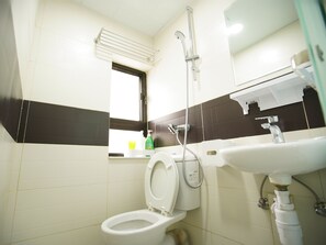 A bathroom with a toilet, a sink, and a shower. - Kong Hing Guest House (Kowloon)