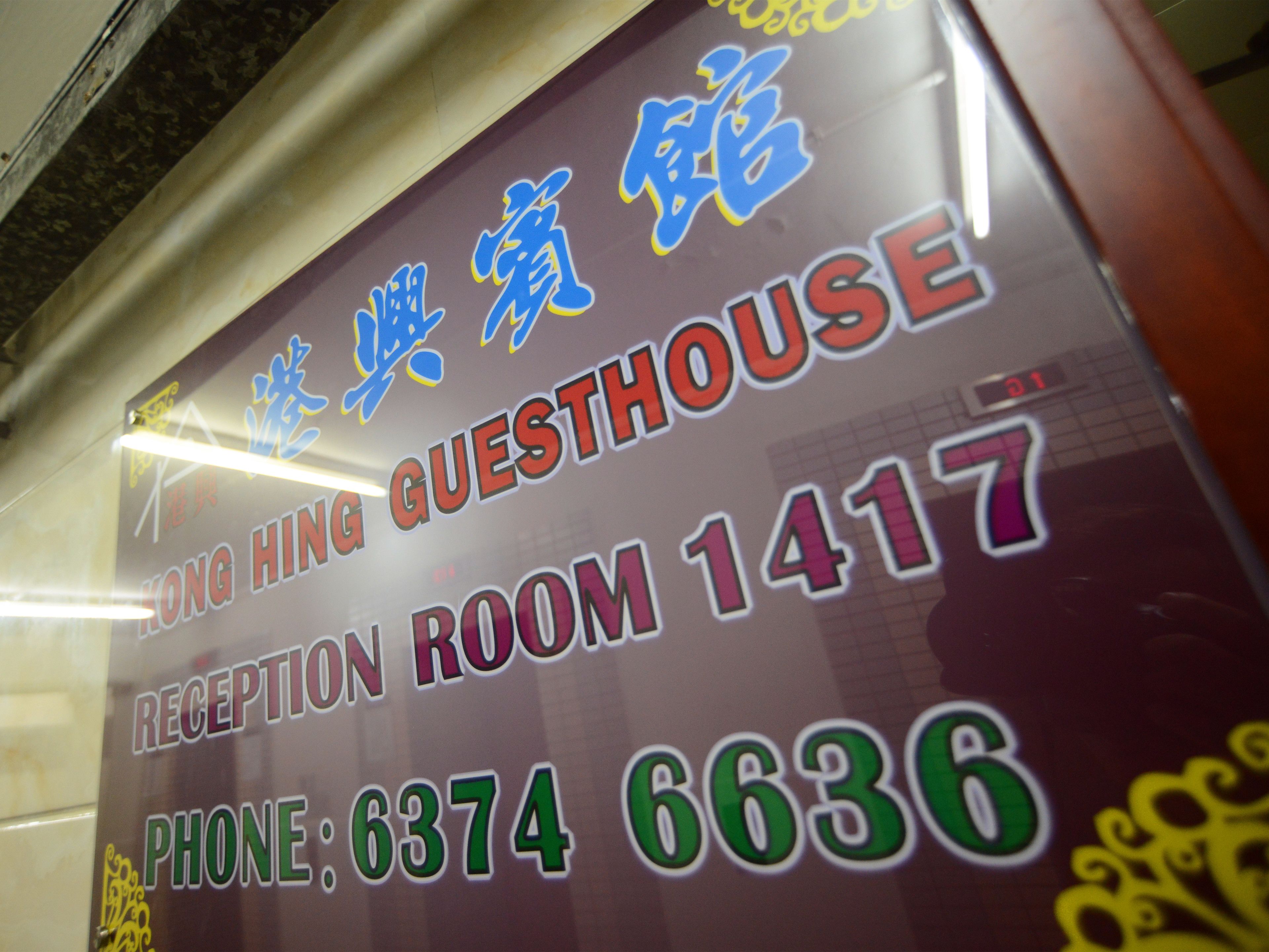 A sign for a hotel room with the name "Hong Hing Guesthouse" and the room number "1417". The phone number "63746636" is also visible.