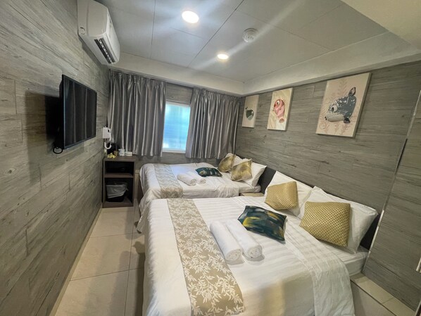 A hotel room with two beds, a TV, a window with curtains, and artwork on the wall. - Kong Hing Guest House (Kowloon)