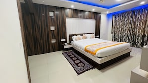 Un dormitorio moderno con una cama grande, una mesita de noche, un ventilador de techo y un panel decorativo en la pared.