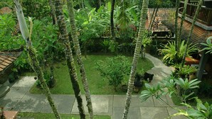 A lush garden with a variety of tropical plants and a small pond. - Jati 3 Bungalows (Ubud)