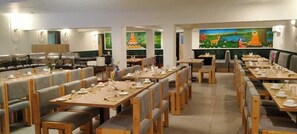 A restaurant with multiple dining tables and booths, equipped with table settings and a buffet area. - Hotel Sujata (Gaya)