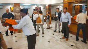A hotel lobby with a reception desk, marble flooring, and a Buddha statue. - Hotel Sujata (Gaya)