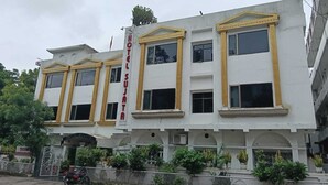 A multi-story hotel with a white facade and yellow trim. - Hotel Sujata (Gaya)