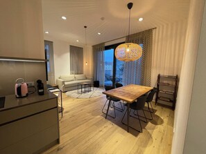 Un espace de vie moderne comprenant une table à manger, un canapé et un coin cuisine.