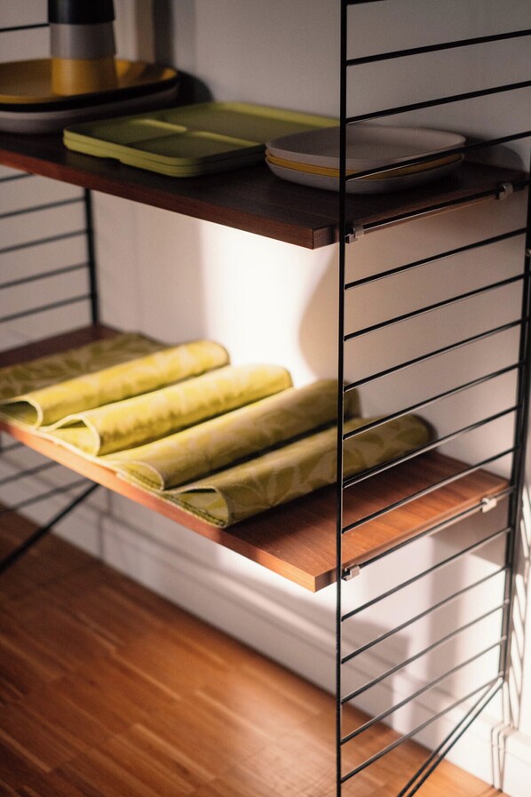 Une étagère de cuisine avec des serviettes enroulées et une machine à café.