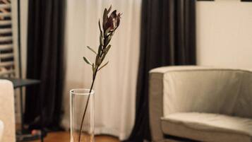 Una mesa de centro de madera con un florero transparente que contiene una planta.