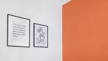 Een vergaderruimte met een houten tafel, vier stoelen en twee ingelijste citaten aan de muur.