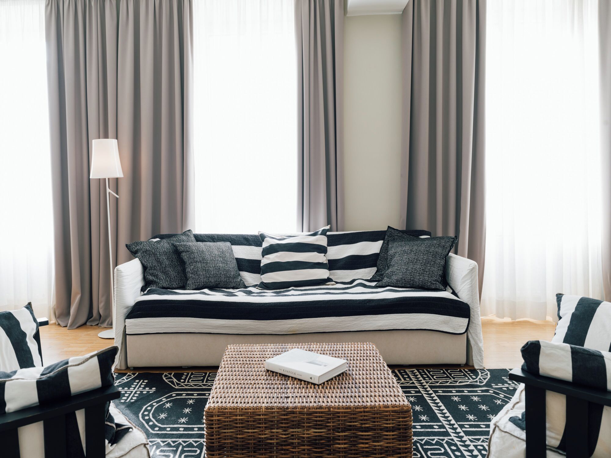 A living room with a sofa, two armchairs, a coffee table, and a floor lamp.