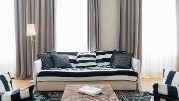 A living room with a sofa, two armchairs, a coffee table, and a floor lamp.