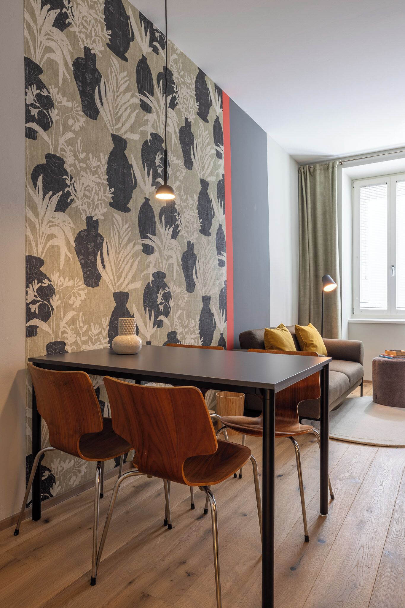 Un'area pranzo moderna con tavolo, sedie e divano.