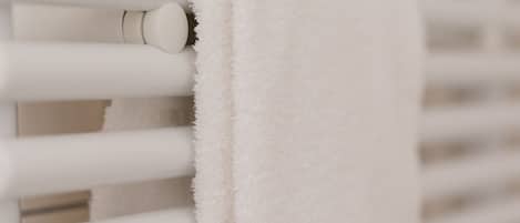 A white towel hanging on a white radiator.