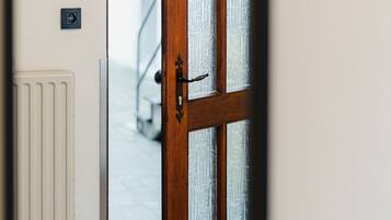 A wooden door with glass panels, a white radiator, and a black and white patterned floor.