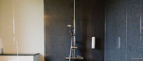 A modern bathroom with a shower, toilet, and a towel rack.