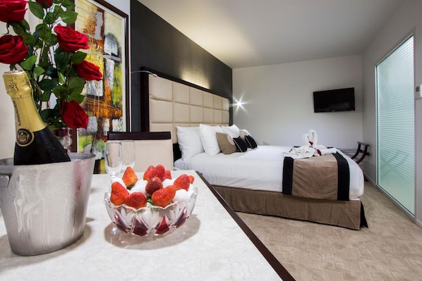 Una habitación de hotel con una cama, una mesita de noche y un amplio ventanal.