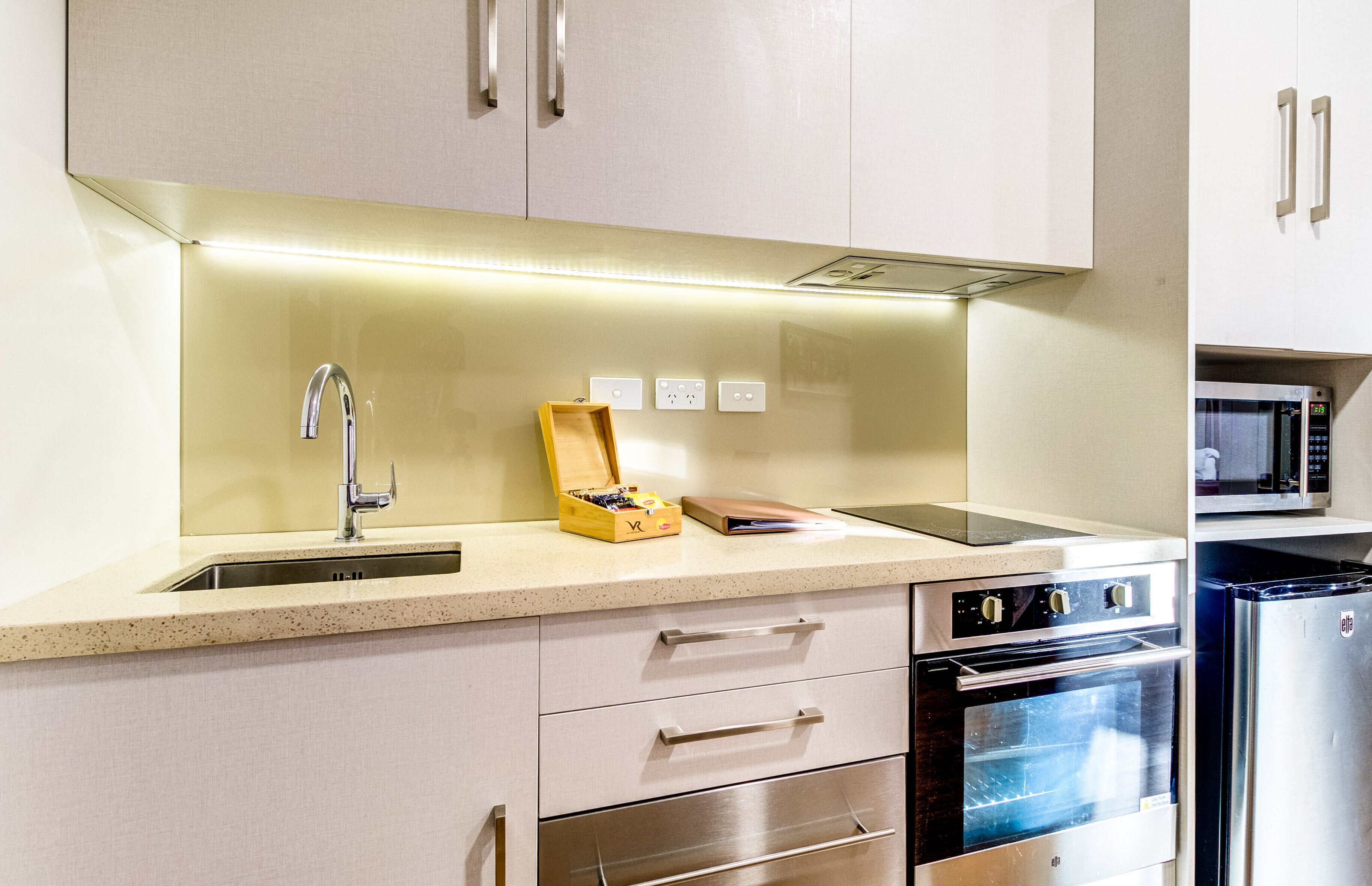 A modern kitchen with stainless steel appliances, a built-in oven, and a microwave.
