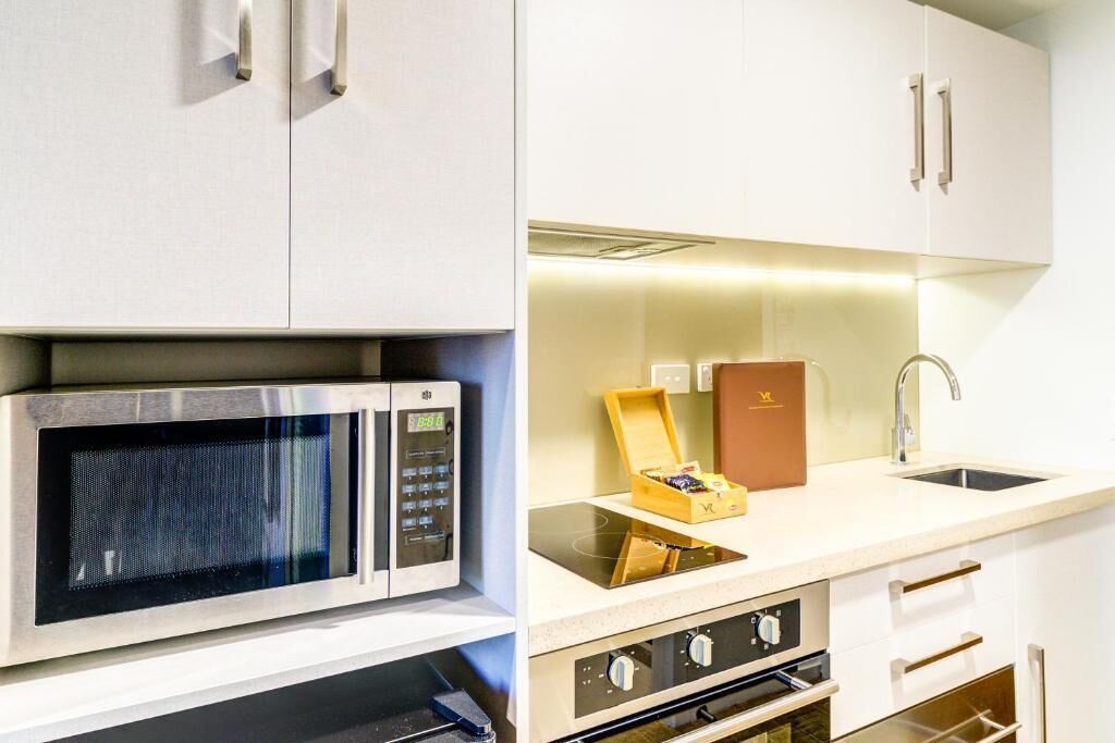 A modern kitchen with stainless steel appliances, a built-in oven, and a sink.